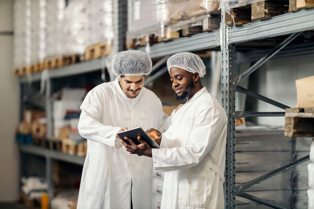 Food specialisten in magazijn met tablet